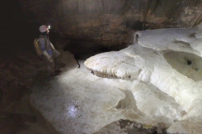 La blancheur des coulées stalagmitiques tranche avec l'ambiance sombre et uniformément argileuse de la plupart des galeries.