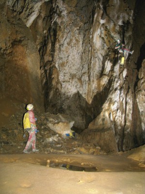 Arrivée dans la galerie fossile (-95 m). Le puits suivant s'ouvre à gauche.